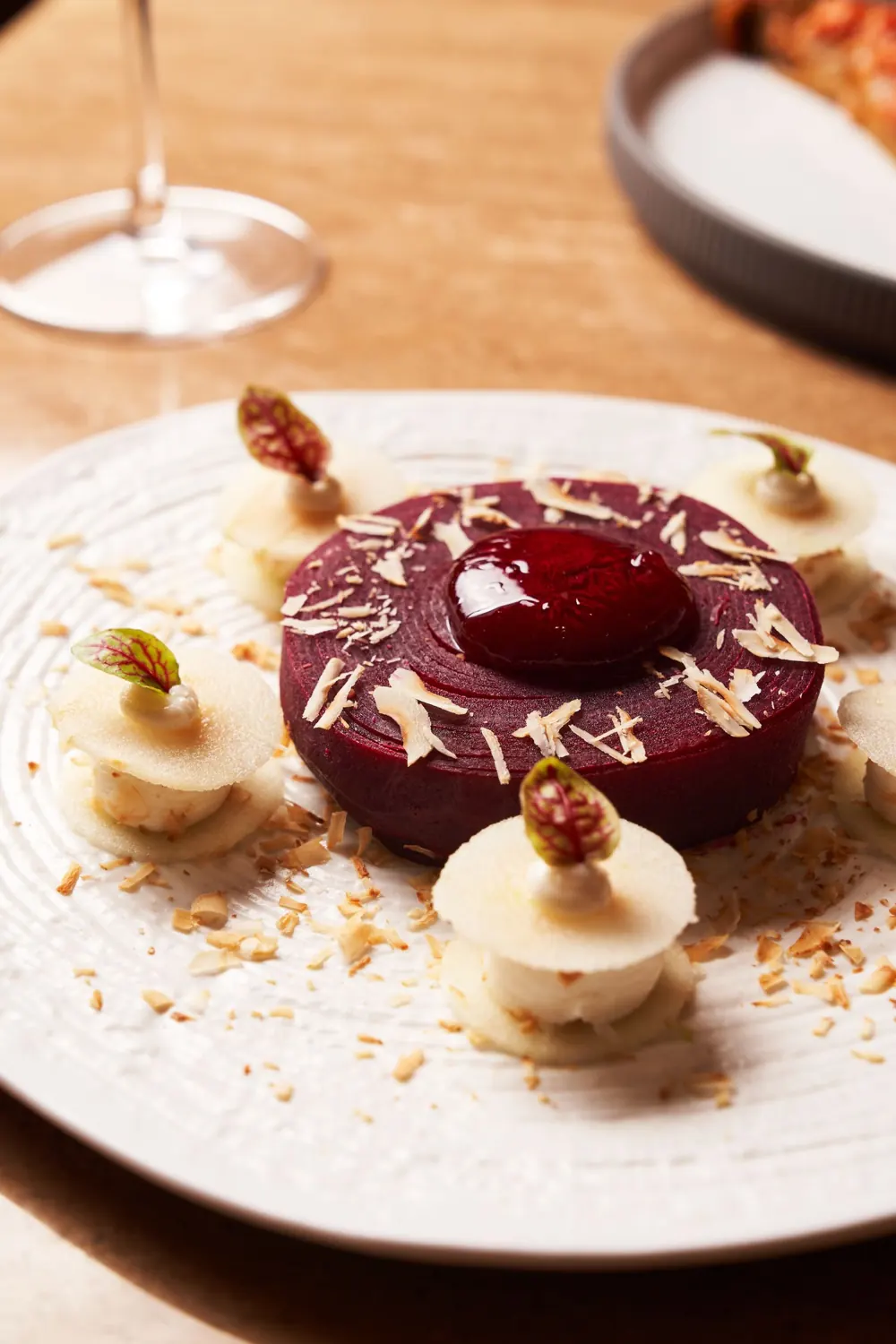 Dessert dressé sur une assiette blanche, verre de vin en arrière-plan